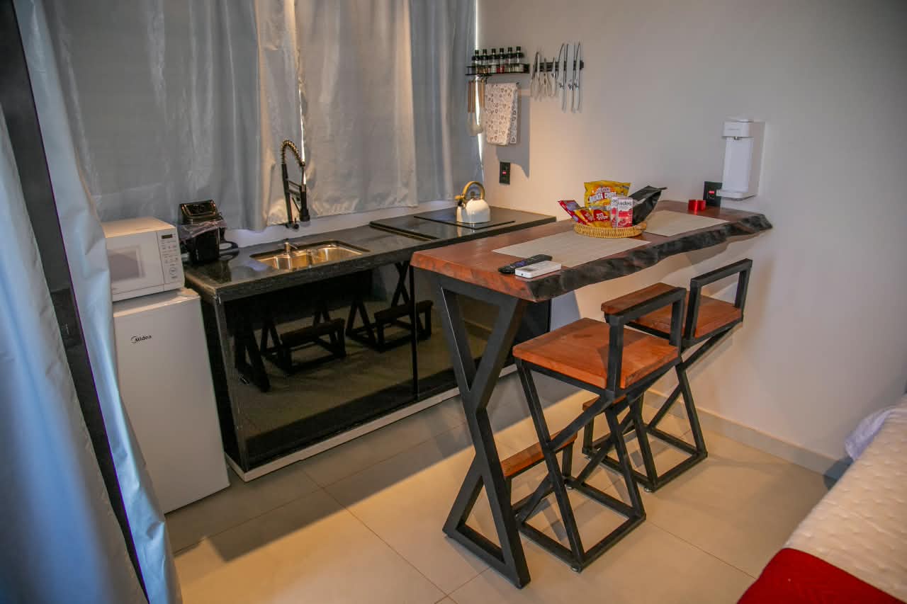 Cozinha compacta equipada com bancada de madeira maciça e banquetas