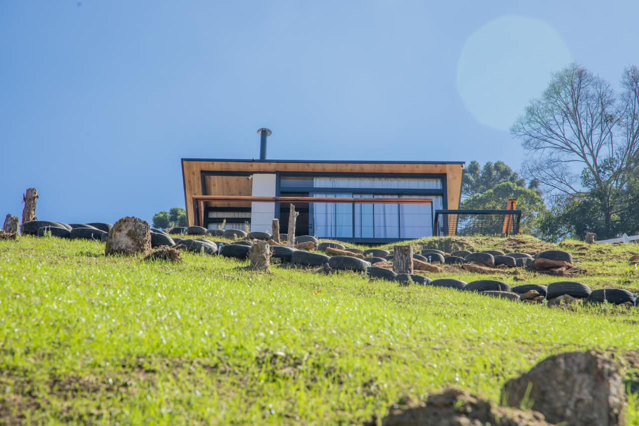 A casa do Recanto do Anil vista do gramado, sob o céu azul da serra